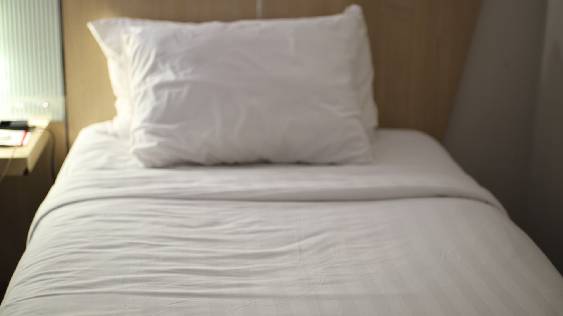 "Minimalist Bedroom with Single White Pillow"